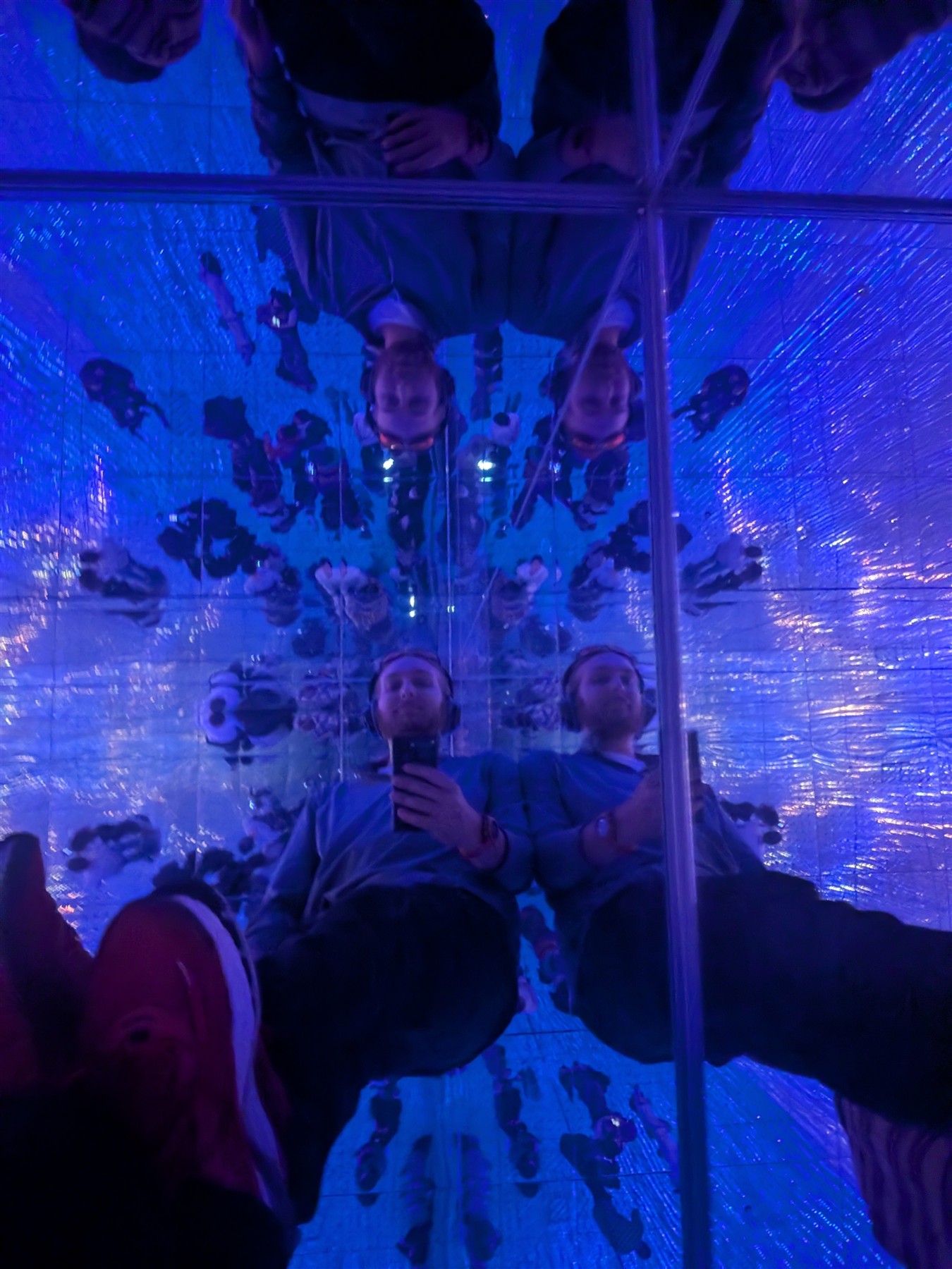 Elijah reflected repeatedly in a blue mirrored installation