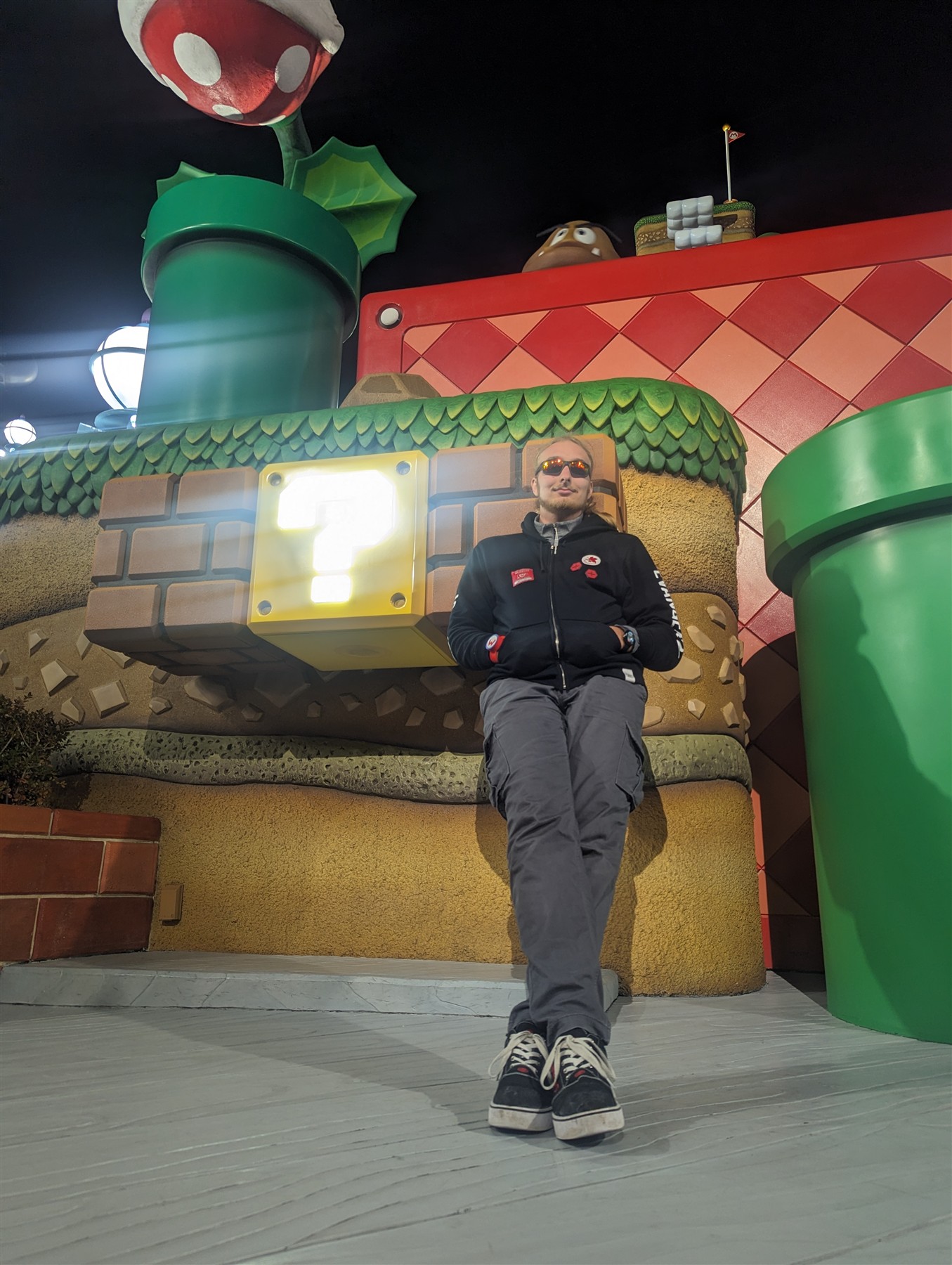 Elijah seated beneath a glowing question block at Super Nintendo World